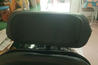 la housse d'appui tête sur un appui tête vue de devant. on vois bien que le tissus suis la forme de l'appui tête