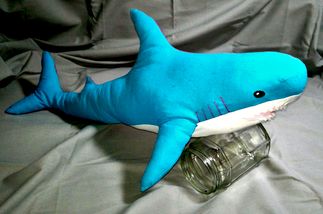 Un requin de profil. il est bleu et ressemble aux requins d'ikea.